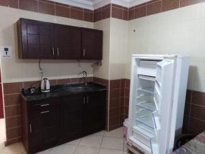艾因苏赫纳Lasirena Resort Aqua Park-Family Only的带冰箱的厨房,门是敞开的