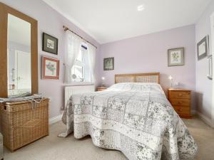 韦尔斯St, Andrews Mews的一间卧室配有一张带鲜花毯子的床和窗户。