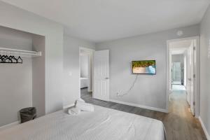 杰汉奈Housepitality - The Gahanna Ranch - 3 BR - Airport的白色卧室配有一张床,墙上挂着一幅画