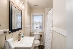 哥伦布Housepitality - The OSU Mansion- OSU Sleeps 20的一间带卫生间、水槽和镜子的浴室