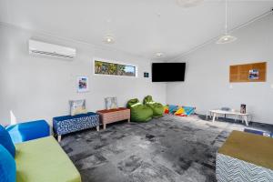 罗托鲁瓦Tasman Holiday Parks - Rotorua的客厅配有椅子和平面电视