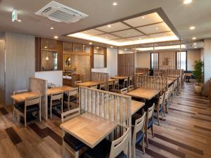 MiyoshiHotel Route Inn Miyoshi Ekimae的用餐室配有木桌和椅子