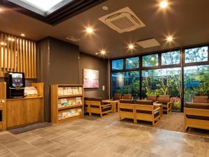 MiyoshiHotel Route Inn Miyoshi Ekimae的一间设有桌椅和窗户的等候室