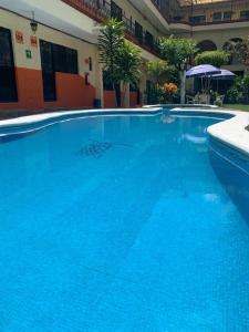 瓦兹特佩克Hotel Plateados Oaxtepec的大楼里的一个大型蓝色游泳池