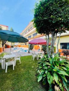 瓦兹特佩克Hotel Plateados Oaxtepec的一组桌子和遮阳伞,位于游泳池旁