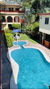 瓦兹特佩克Hotel Plateados Oaxtepec的一座房子的院子内的游泳池