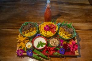 蒙泰韦尔德哥斯达黎加El Sol Monteverde的桌上放着一碗食物和鲜花的托盘