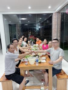 巴位Kazin Homestay Ba vì的一群坐在餐桌上吃食物的人