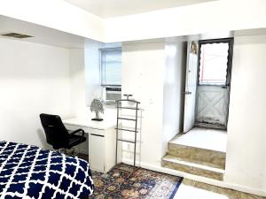 长岛市Manhattan in 2 stopages, 2 Bedrooms Apt with private Backyard in LIC !!!的一间卧室配有一张床、一张桌子和一把椅子