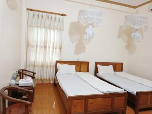 Minh Loan Hotel的一间卧室配有两张床和吊灯。