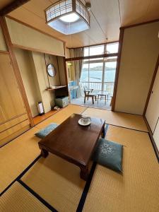 土庄町入舟旅馆的客厅设有木桌和大窗户。