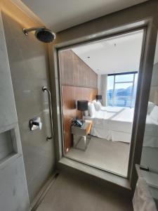 里约热内卢Hotel Nacional的一间带镜子、一张床和淋浴的浴室
