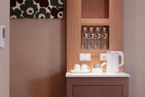 高雄康桥商旅 - 觉民馆的一间设有咖啡壶和眼镜的柜台的房间