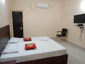 布巴内什瓦尔Goroomgo Green Akress Bhubaneswar的卧室配有带红色枕头的大型白色床