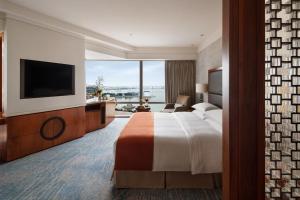 澳门Mandarin Oriental, Macau的配有一张床和一台平面电视的酒店客房