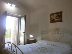 奥斯图尼Trullo Villa Giuliana con giardino Posizione panoramica Free wifi的卧室配有白色的床和窗户。