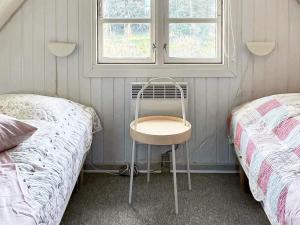 灵克宾Holiday Home Strandgårdsvej III的配有两张床和窗户的房间的椅子