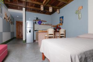埃斯孔迪多港Nopalero Suites Hostel的一间带白色床的卧室和一间厨房