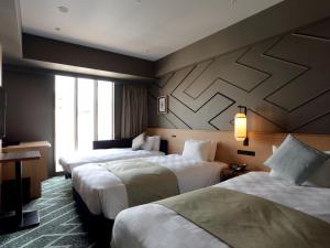 东京Asakusa View Hotel Annex Rokku的酒店客房设有两张床和窗户。