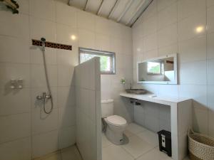 乌鲁瓦图Alam Cottage Uluwatu的浴室配有卫生间、盥洗盆和淋浴。