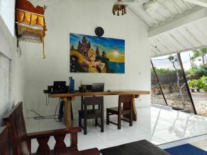 乌鲁瓦图Alam Cottage Uluwatu的一间房间,配有一张桌子和一台笔记本电脑