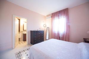 奥尼萨诺Relais il Melograno的一间卧室配有一张床、一个梳妆台和一扇窗户。