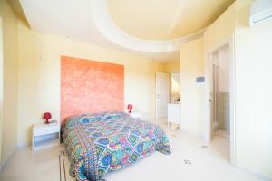 奥尼萨诺Relais il Melograno的一间卧室配有一张带彩色床罩的床