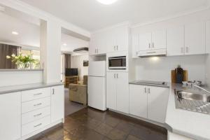 卡尔斯Island Breeze Resort的厨房配有白色橱柜和水槽