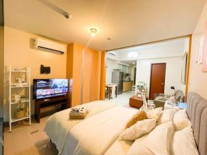 马尼拉Deluxe 1br - Uptown - Netflix, Pool #oursw15o的一间卧室配有一张大床和一台平面电视