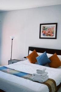 卡马拉海滩Sasimanta的一间卧室配有带橙色和蓝色枕头的床