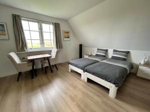 德科赫Landhuis Mariëtta的一间卧室配有一张床、一张书桌和一个窗户。