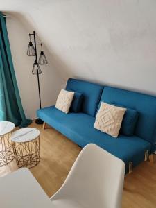 滨海贝尔克200 m plage - Rue piétonne à 300 m - jardin的客厅设有一张蓝色的沙发,配有两张桌子