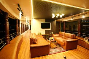 阿勒皮IndraprasthamLakeCruise的客厅配有真皮沙发和电视