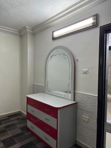 伊尔比德شقة مفروشة للايجار的浴室设有红色梳妆台和镜子
