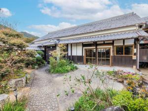 Fukusaki姫路城の奥座敷　築400年の宿 鐵十郎（登録文化財）的前面有石头走道的房子
