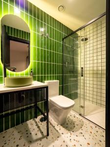 托莱多Wonder Hostel的绿色瓷砖浴室设有卫生间和淋浴。