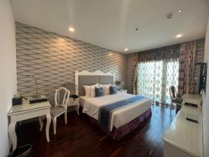 土龙木市米拉酒店的一间卧室配有一张床、一张桌子和一张书桌