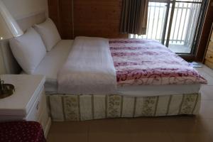 和平区星光山悦景觀民宿的一间卧室配有一张带粉色毯子的床