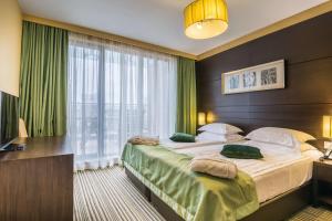 索非亚Best Western Plus Olives City Hotel - Free Parking的一间卧室设有一张大床和一个大窗户