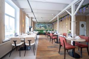 德文格洛弗莱彻酒店 - 博肯餐厅的餐厅设有桌椅和窗户。