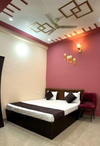 瓦拉纳西Hotel Chandra Dreams的一间卧室设有一张床和红色的墙壁