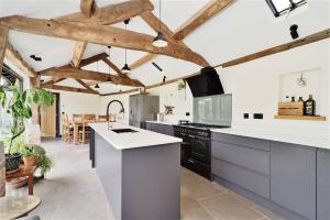 赫里福德The Cart House - Rural Retreat的厨房配有白色的台面和木制天花板