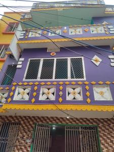 普里JHARANA GUEST HOUSE的一座带窗户和奥克的紫色屋顶建筑