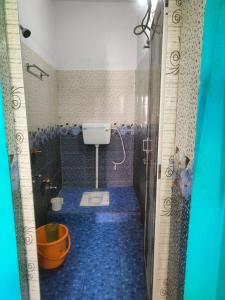 普里JHARANA GUEST HOUSE的浴室铺有蓝色地板,设有卫生间。