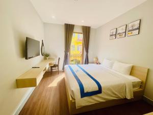 富国Sunny Hotel Phu Quoc- Free cable car ticket to Hon Thom的一间卧室配有一张床、一张书桌和一台电视