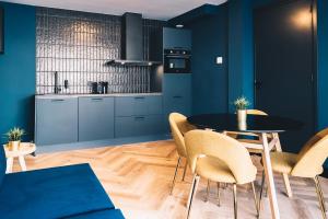 海牙LVM Stays的厨房配有蓝色橱柜和桌椅