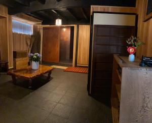 高野山Koyasan Space的一间带桌子的客厅和一间厨房