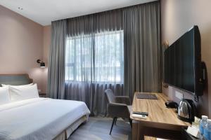 哥打京那巴鲁杰塞尔顿酒店的酒店客房配有一张床和一张书桌及一台电视