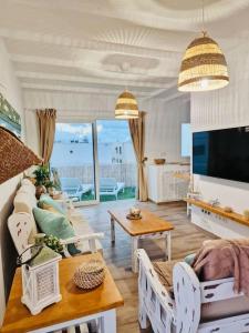 宏达海滩Callao beachhouse的带沙发和电视的客厅