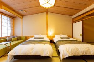 安来市鷺温泉酒店的一间客房配有两张床和一张沙发